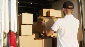 man putting boxes in the back of a truck