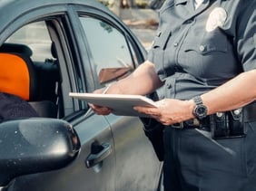 person pulled over and getting a ticket from a police officer